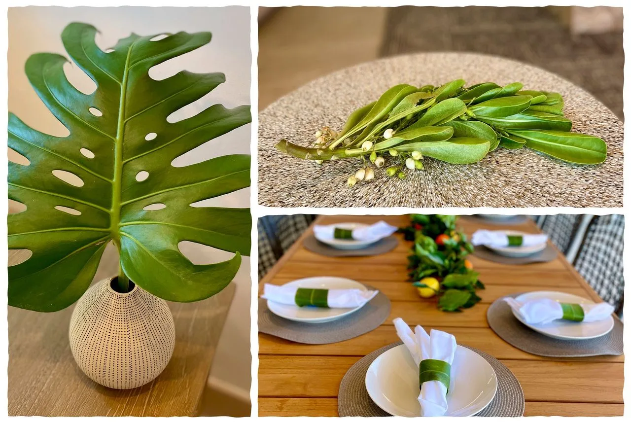 Decorative leaves in a vase and greenery arranged on a dining table.