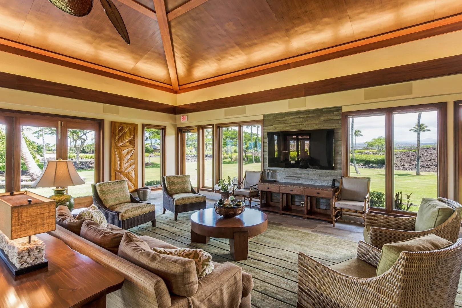 A spacious living room with seating arranged around a coffee table and television.