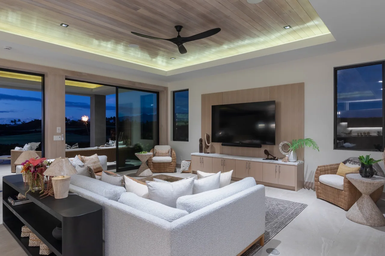 A modern living room with a large sectional sofa facing a wall-mounted television.