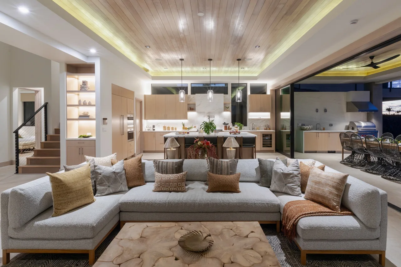 A spacious living room with a sectional sofa facing an open kitchen.