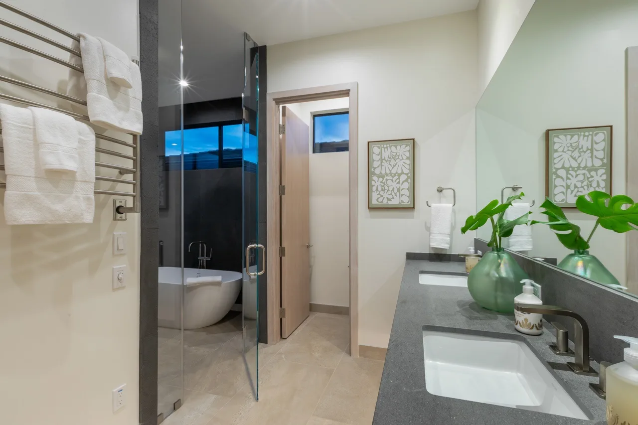 A bathroom with a glass shower, bathtub, and sink.