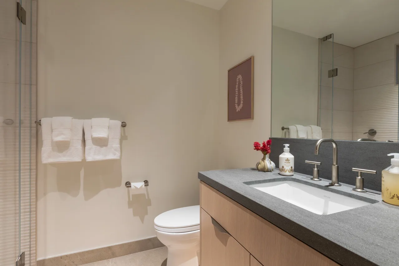 A bathroom with a wide vanity, sink, and wall-mounted towels.