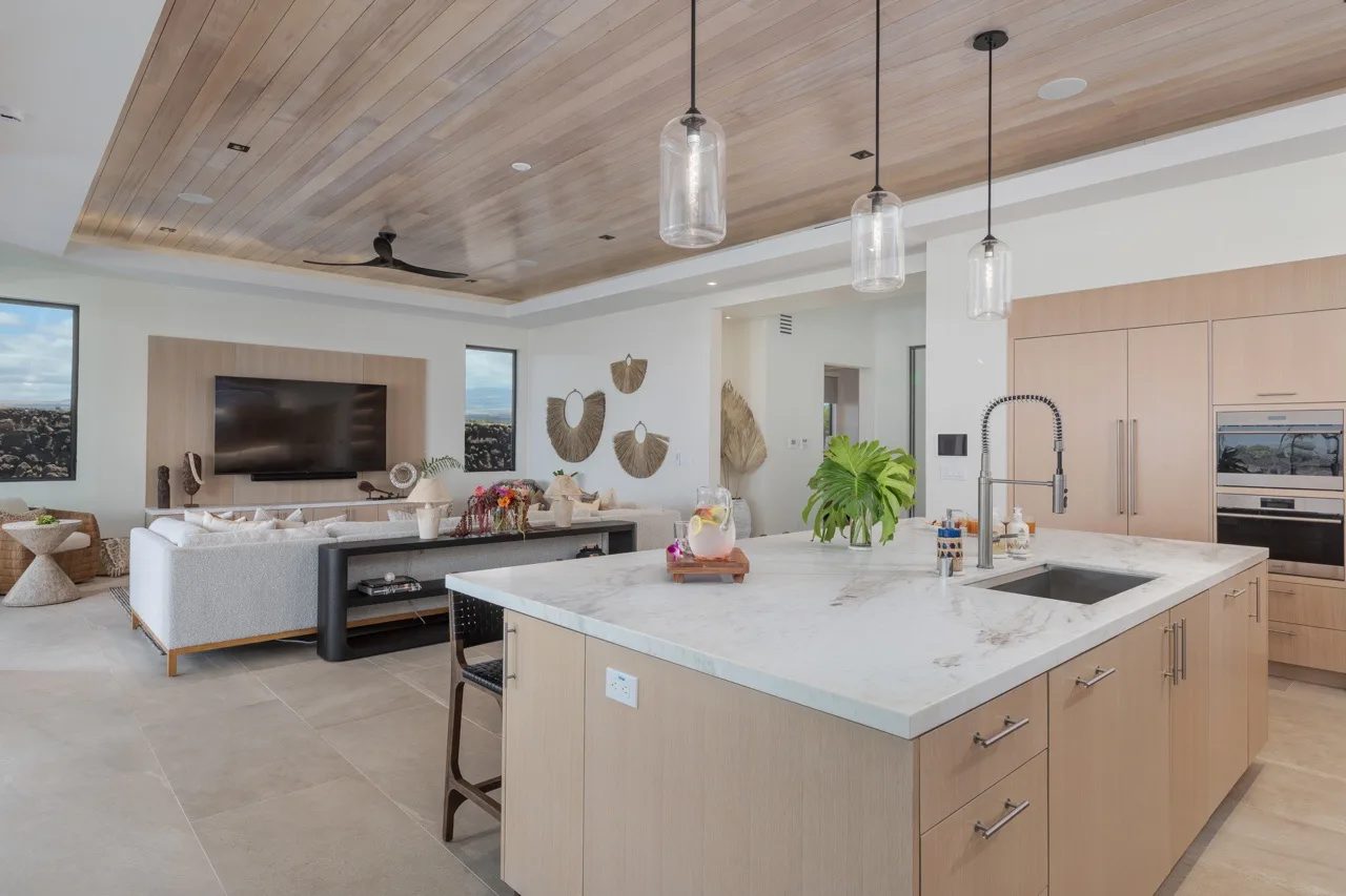 A bright open-plan kitchen and living area with a large central island.