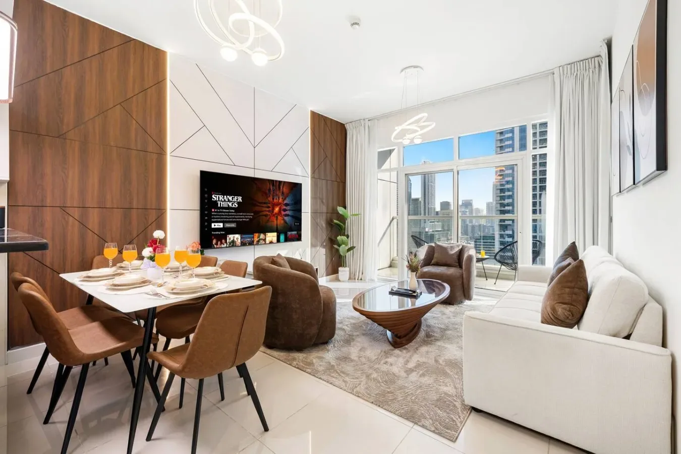 An open-plan living and dining area with seating beside large windows.