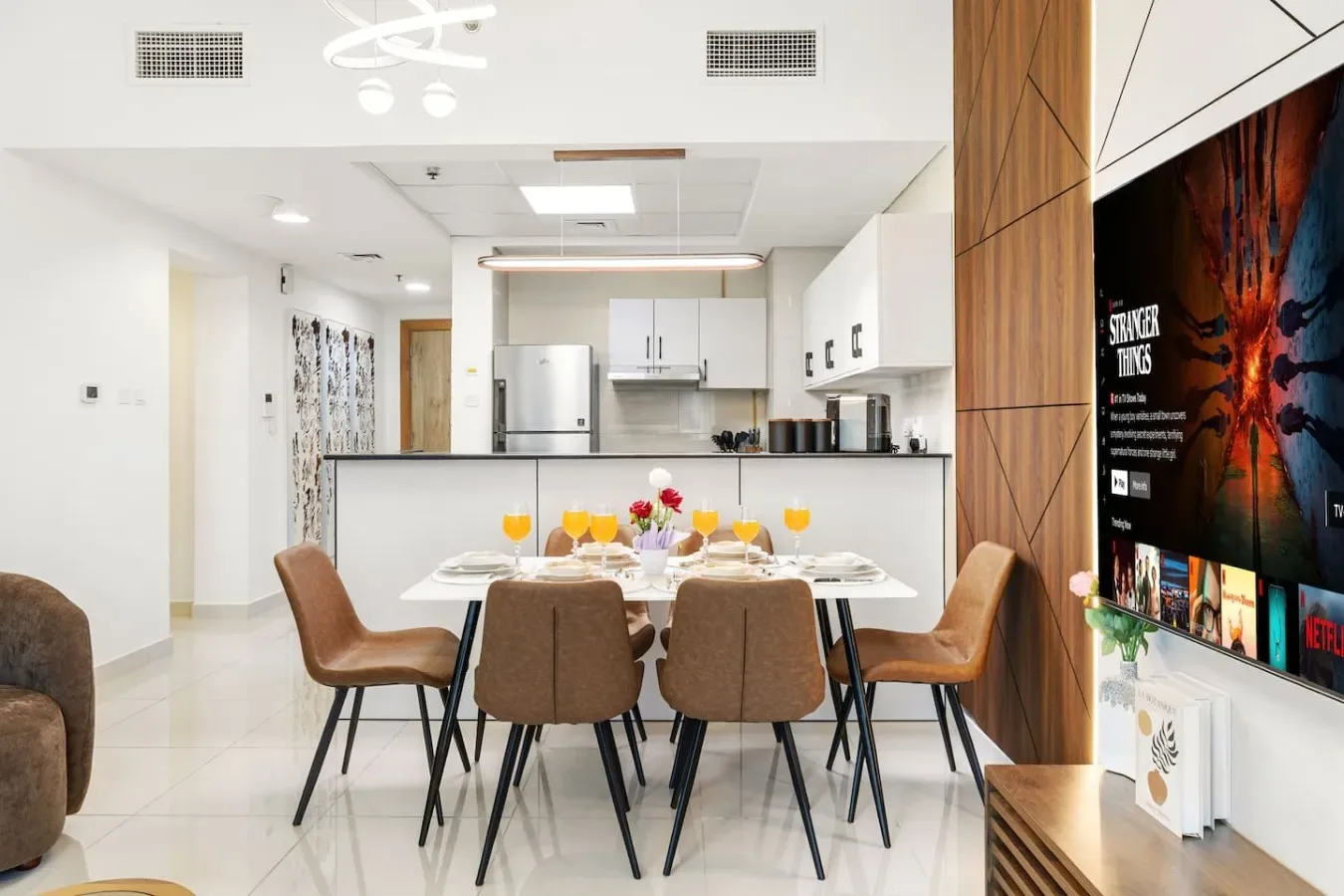 A dining area with a set table beside an open kitchen.