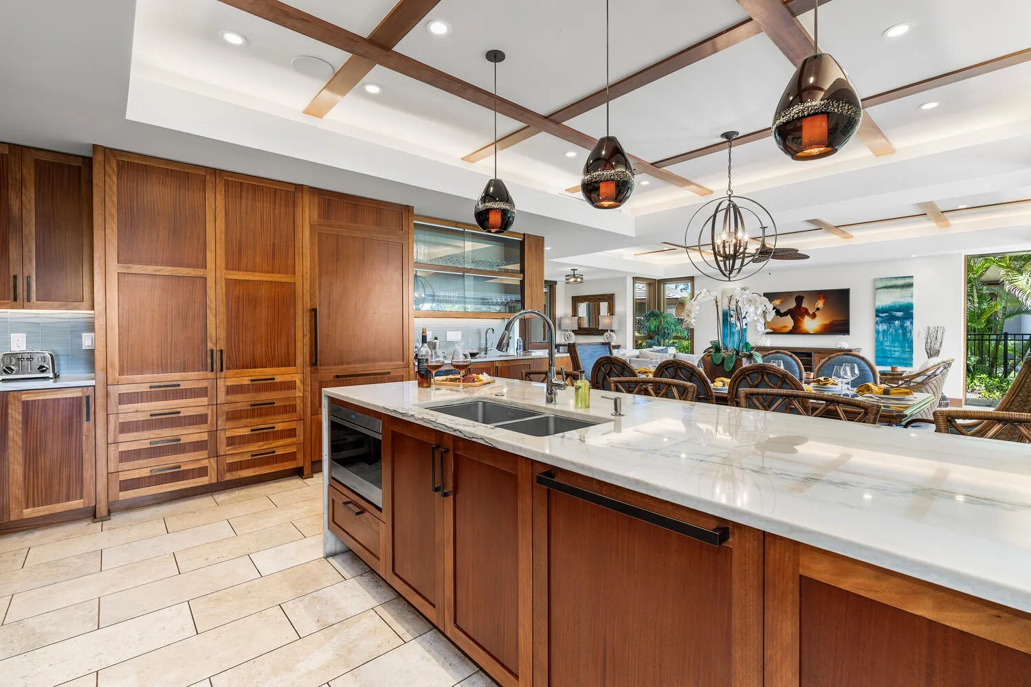 Una cocina amplia con gabinetes de madera e isla grande se abre a un comedor.