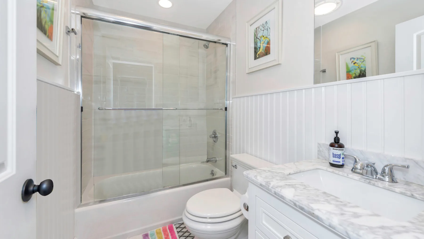 Un baño con ducha de vidrio, inodoro y tocador.