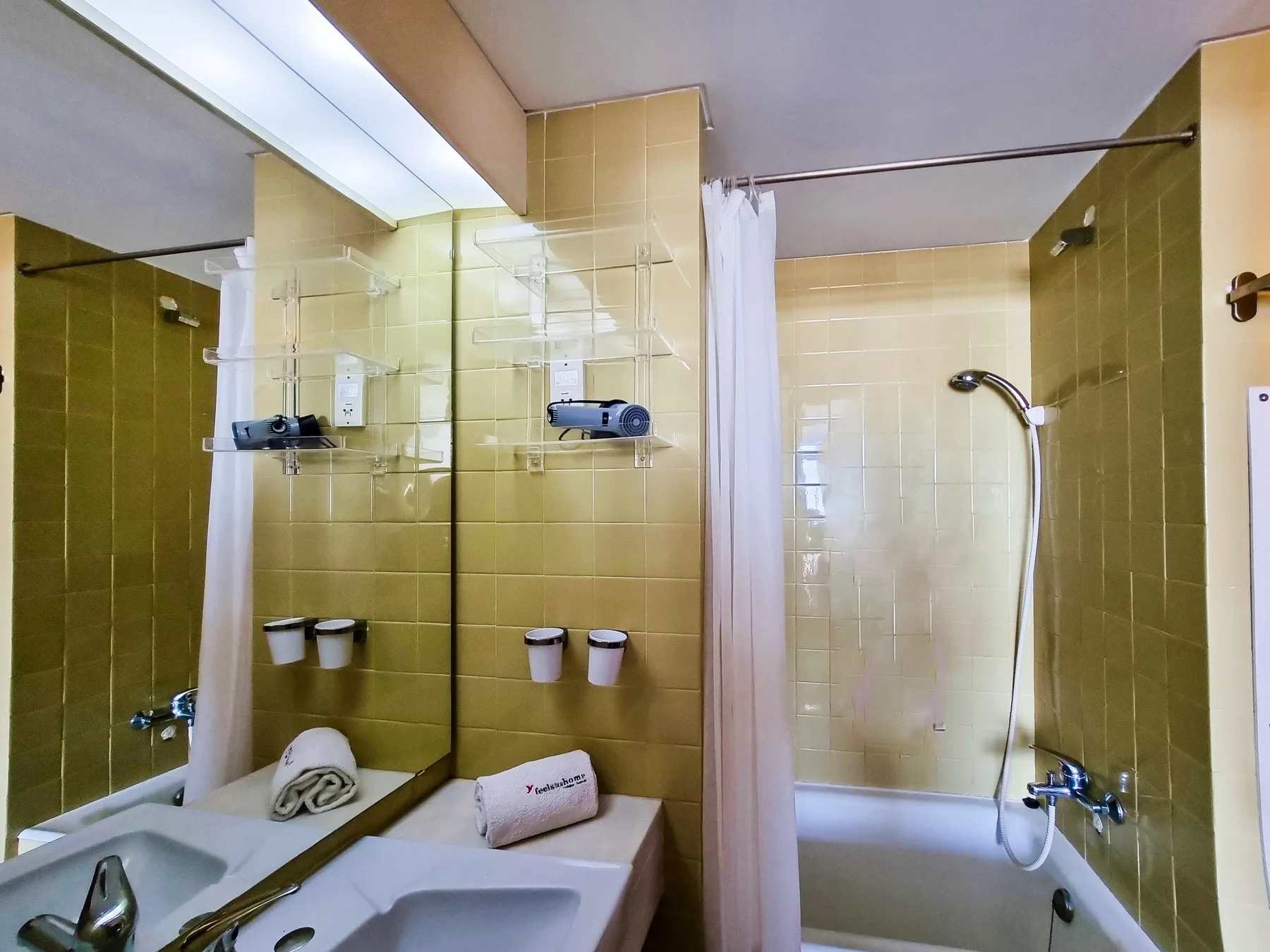 Baño con lavabo, espejo y ducha.