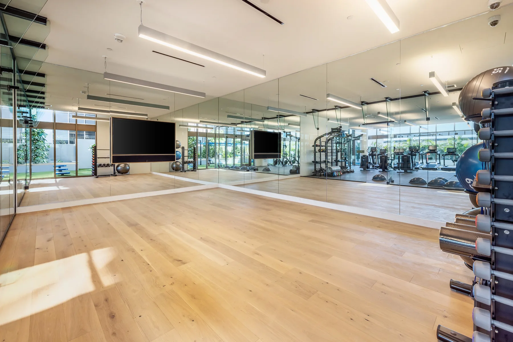 A spacious fitness studio with mirrored walls and exercise equipment.