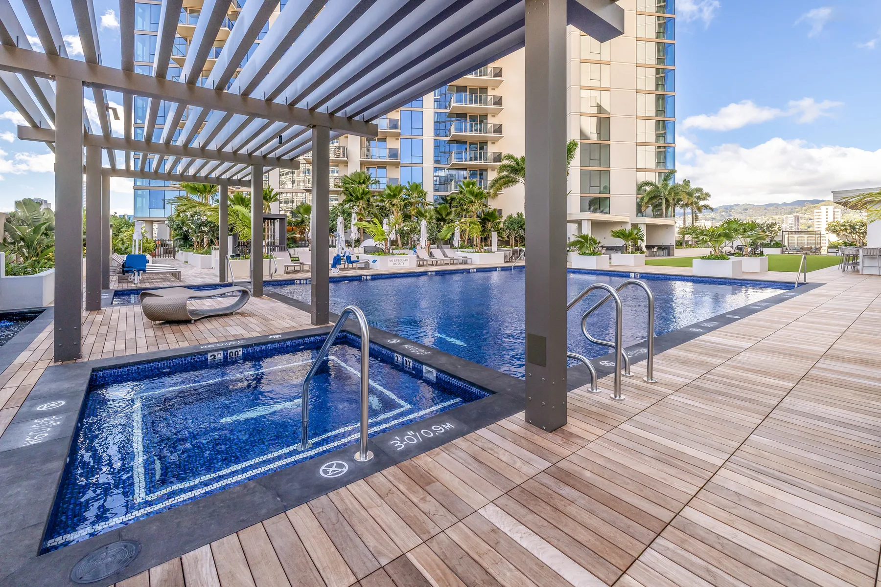 An outdoor pool area with a smaller pool beneath a pergola.