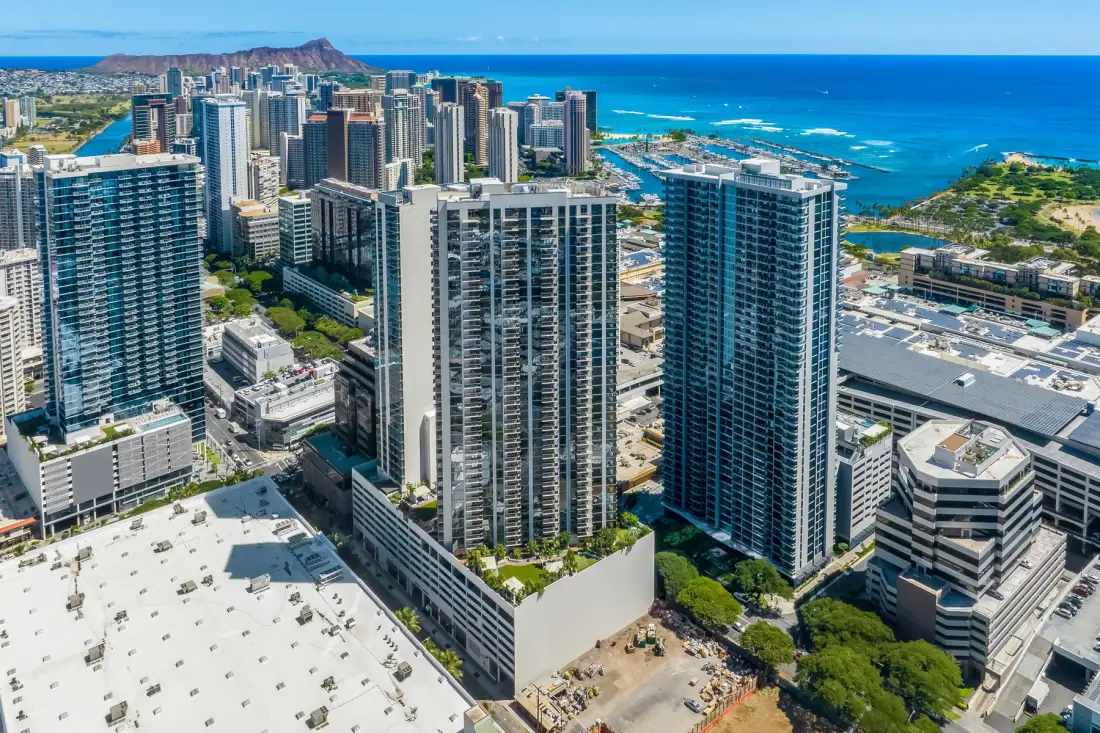 Aerial view of high-rise buildings along a turquoise coastline.