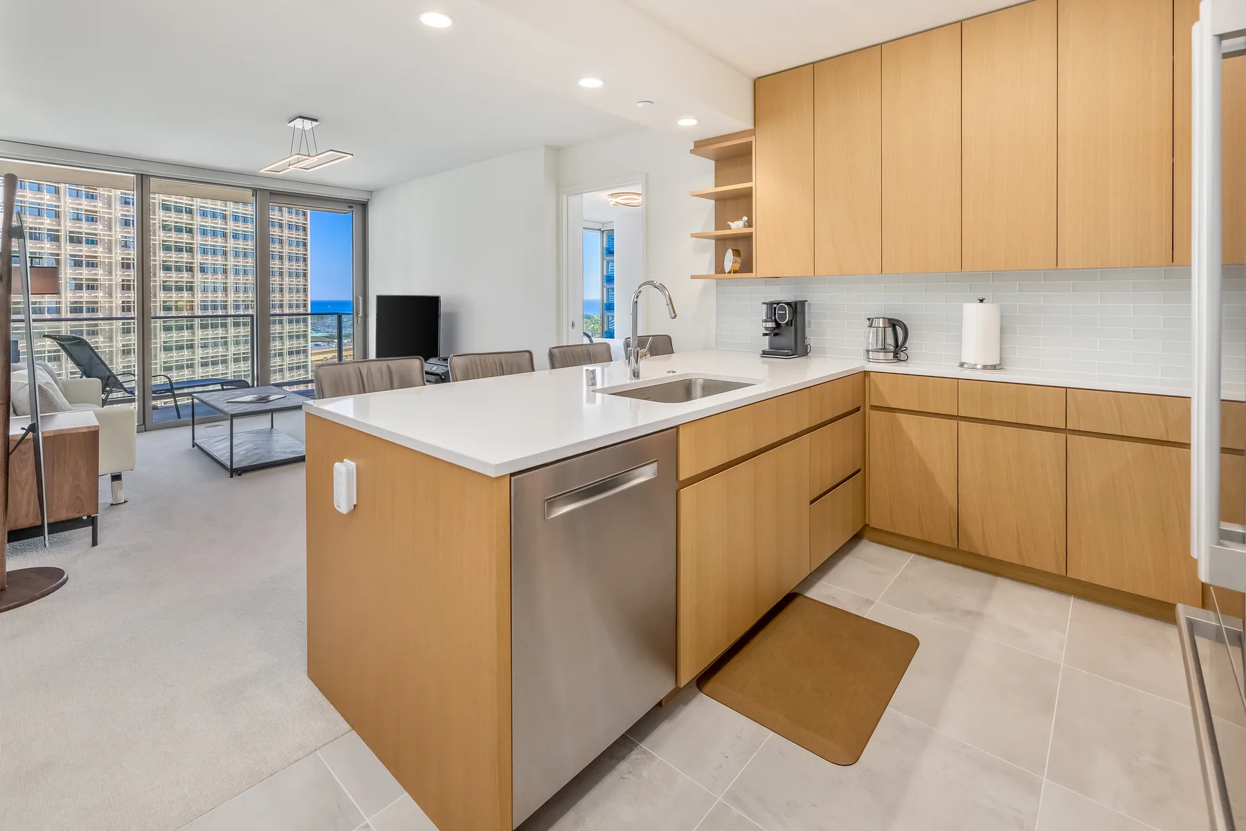 An open-plan kitchen and living area with a central island and large windows.