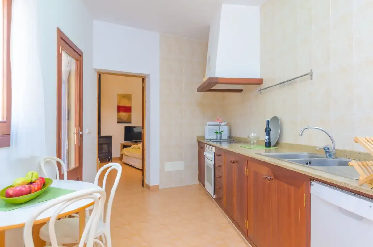 A bright kitchen with wooden cabinets and a dining table.