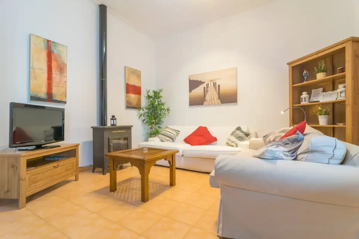 A living room with a television, seating, and a wooden coffee table.