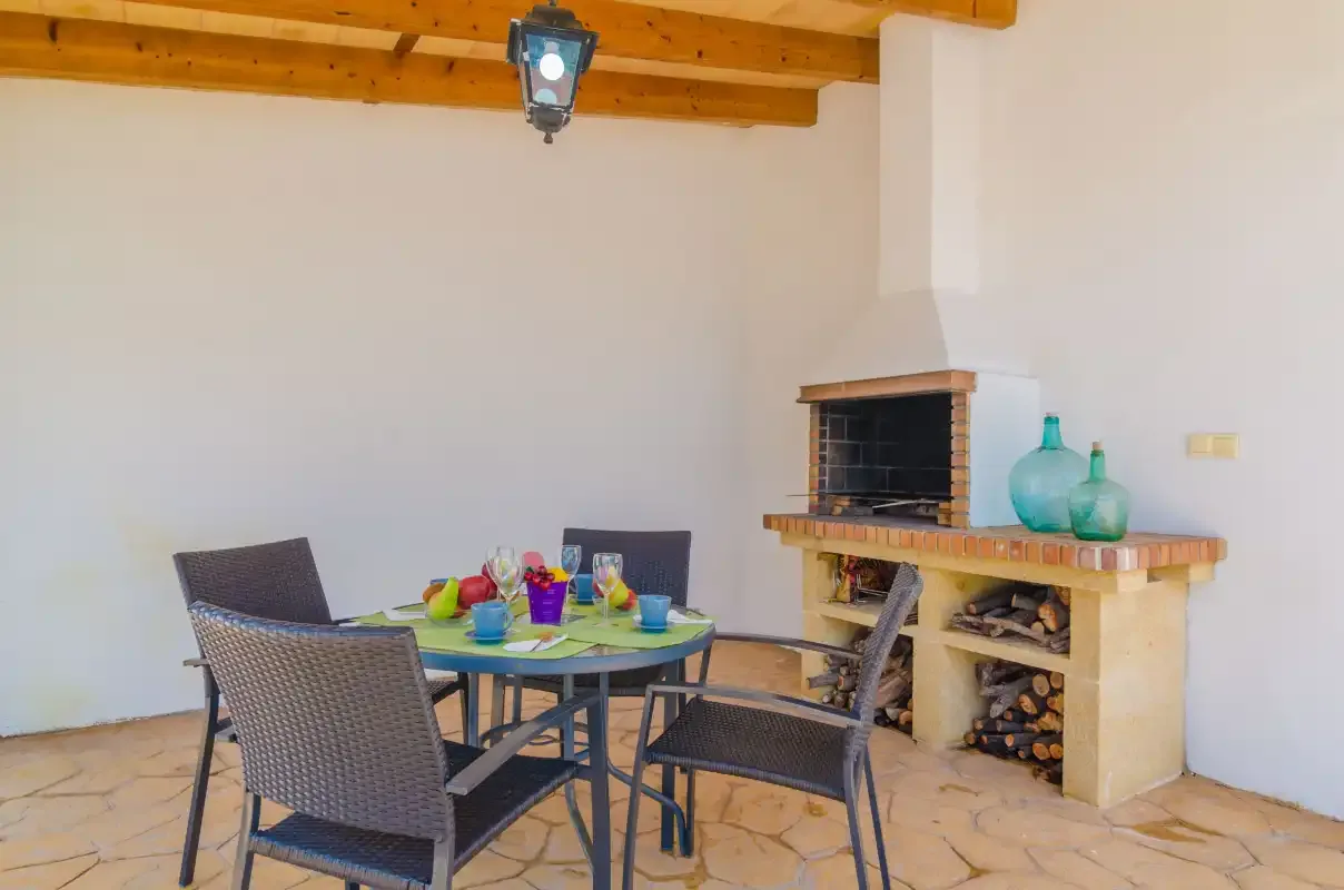 A dining area with a table and chairs beside a fireplace.