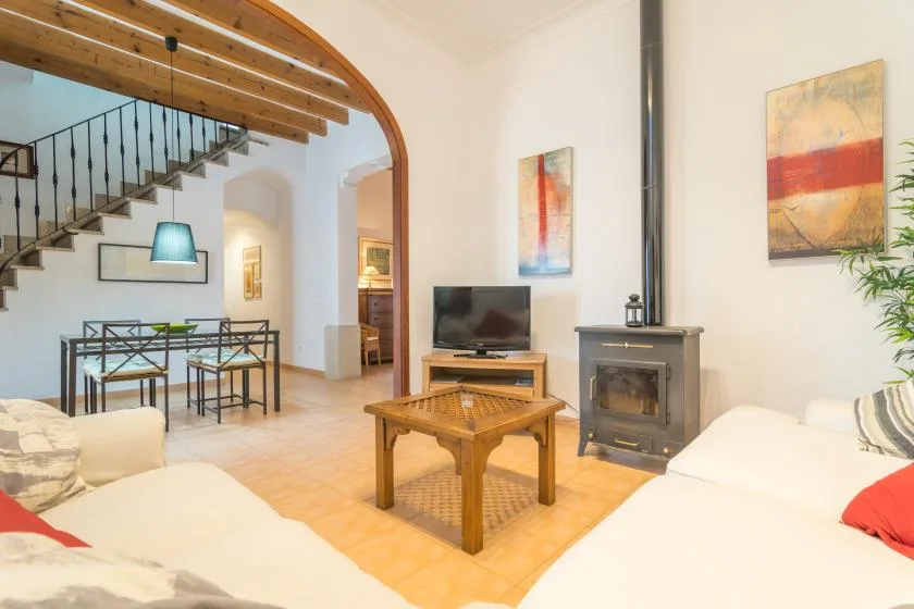 A bright living room with seating, a coffee table, and a freestanding stove.