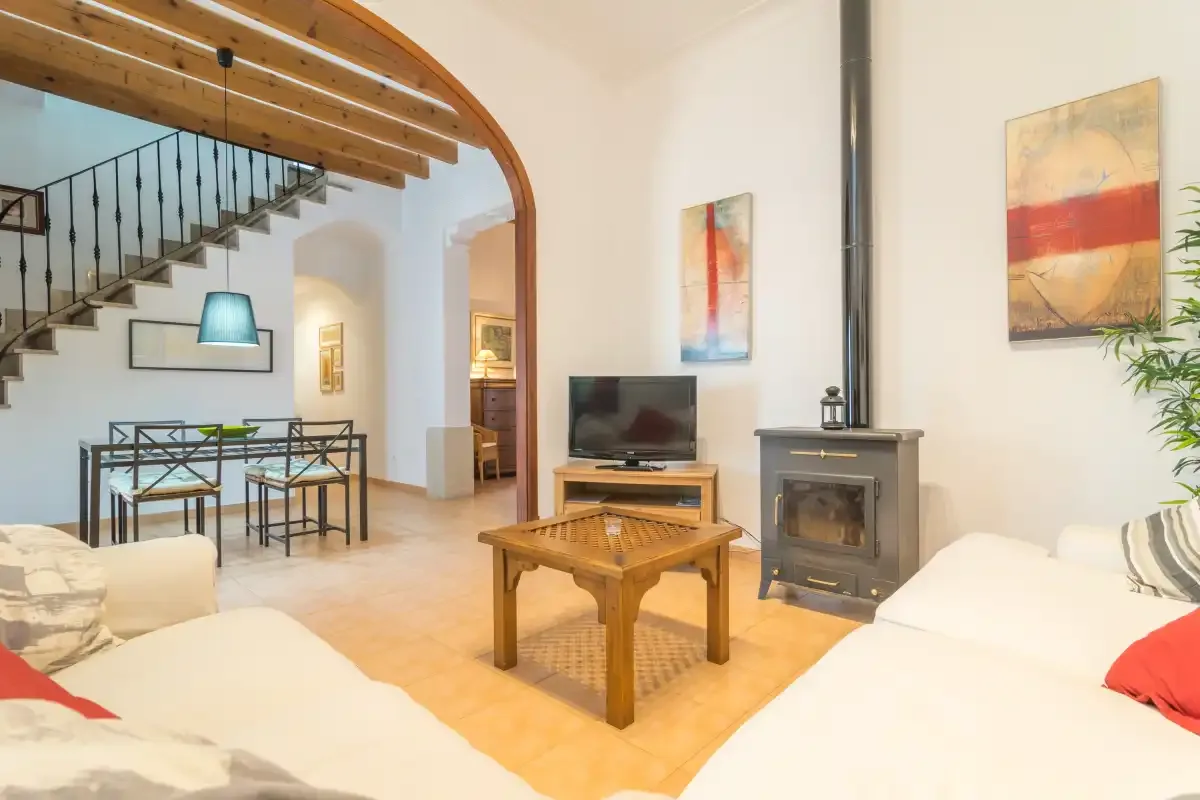 A living room with seating, a coffee table, and a wood-burning stove.