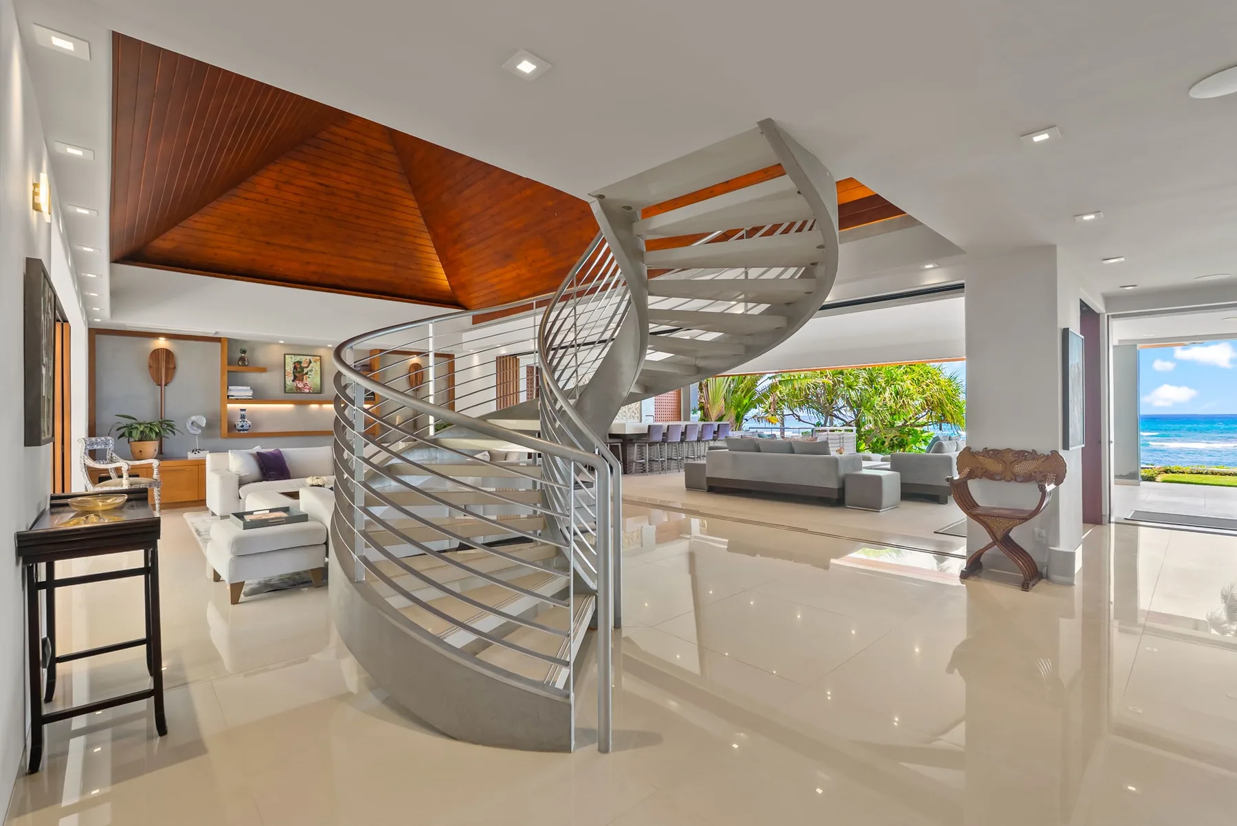 A bright open living area features a curved spiral staircase and seating.