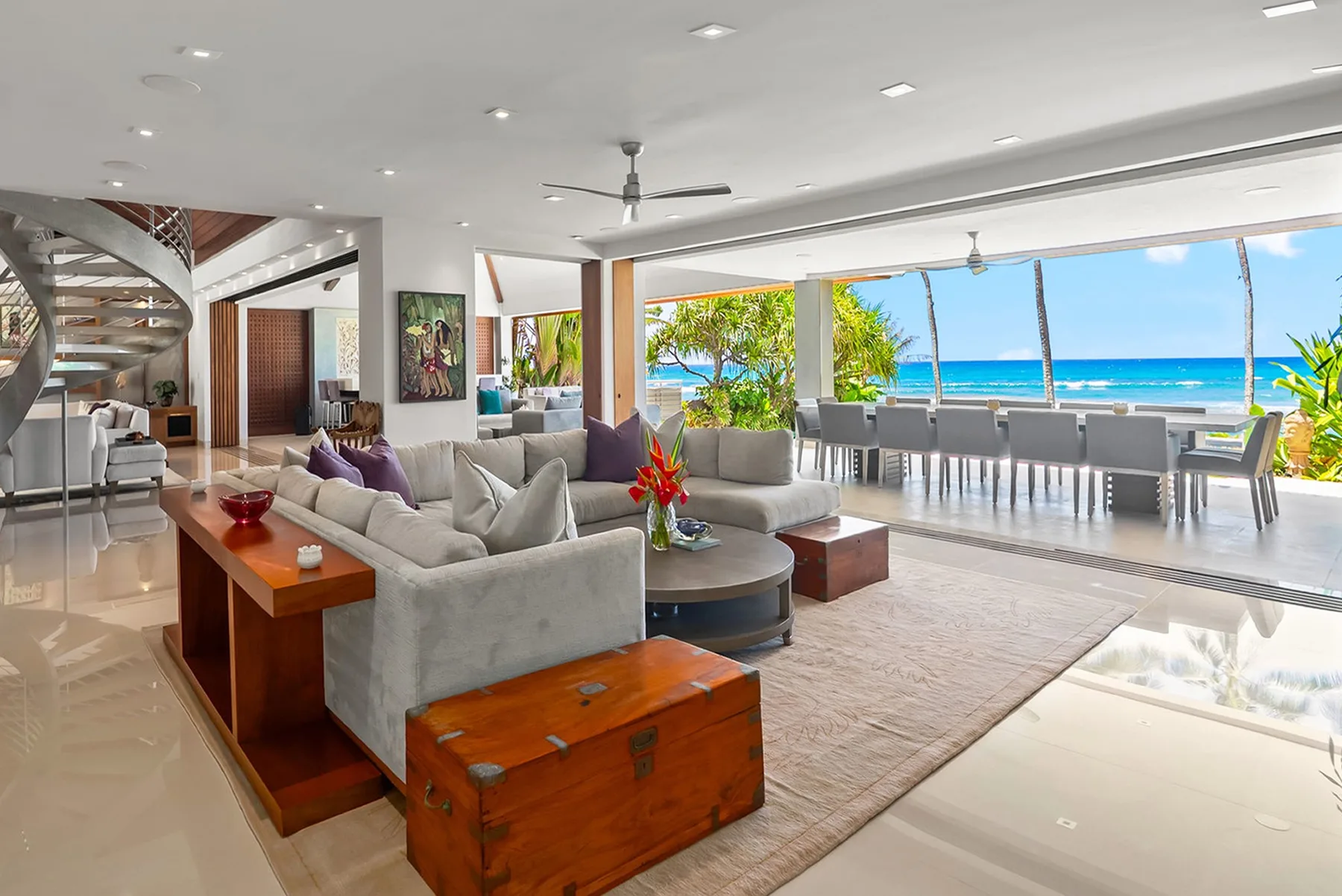 An open living and dining area with seating and a view of the ocean.