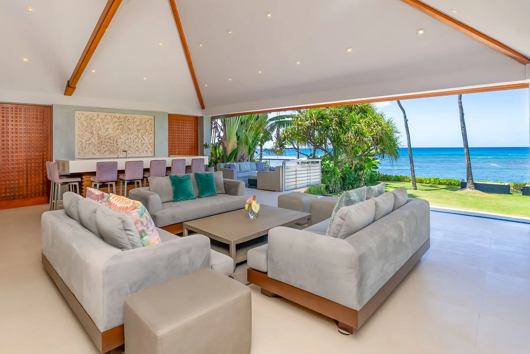 An open living room with seating and a view of the ocean.