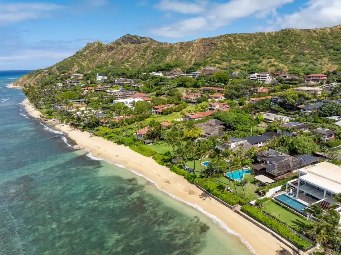 Aerial view of a coastal neighborhood with homes along a sandy beach.
