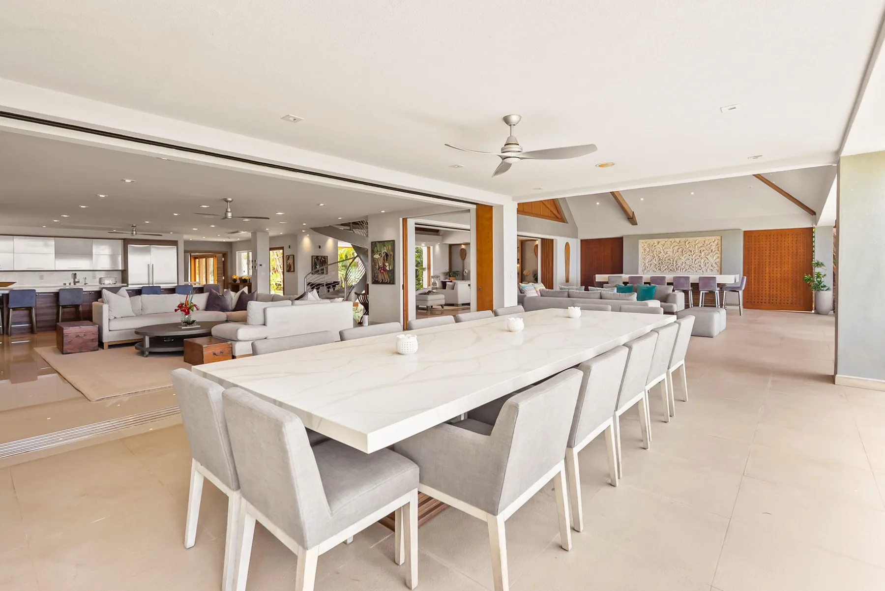 A spacious open-plan dining and living area with a long table and seating.