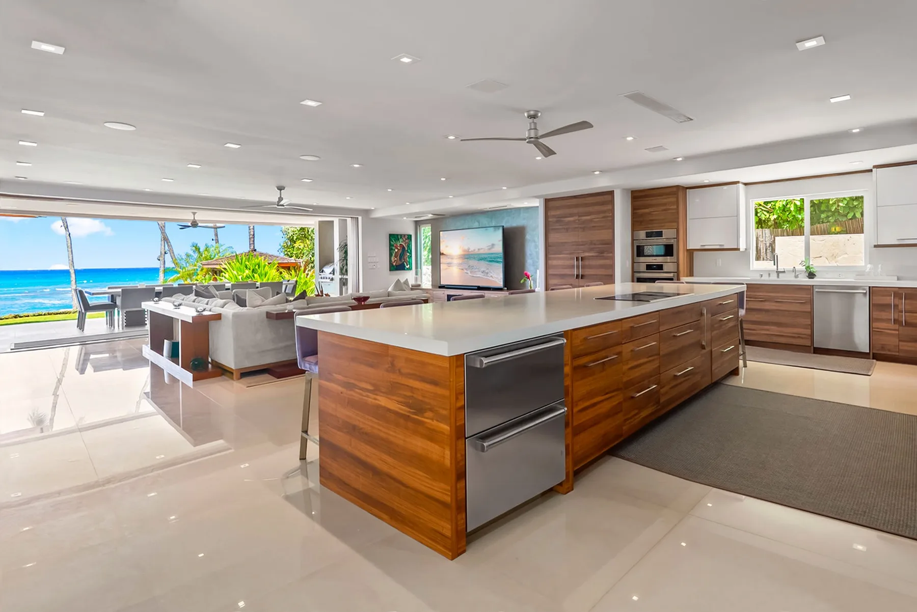 A spacious open-plan kitchen with a large island and a living area overlooking the ocean.