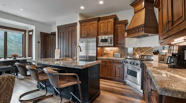 A kitchen with wooden cabinetry, stainless steel appliances, and a central island.