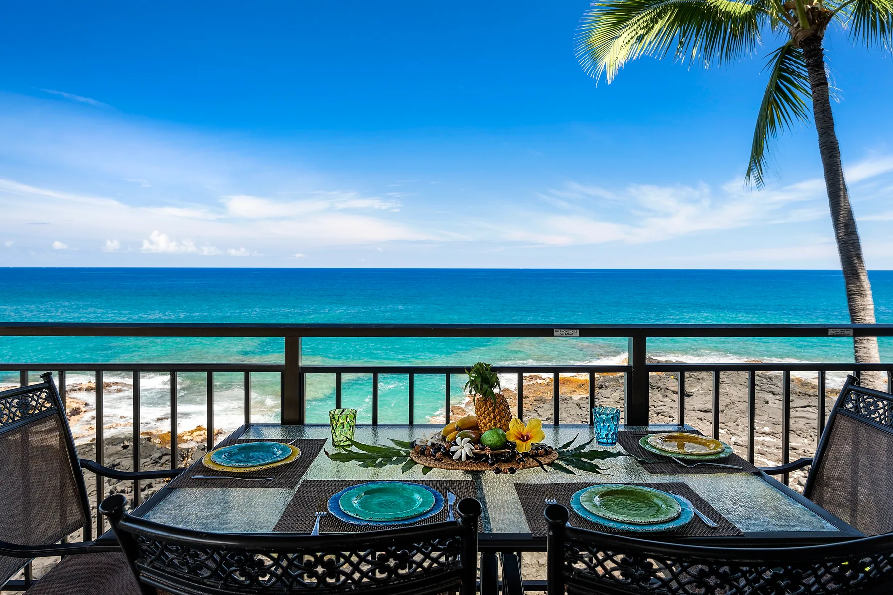 Una mesa de comedor junto al mar, con cubiertos, mira hacia el océano.