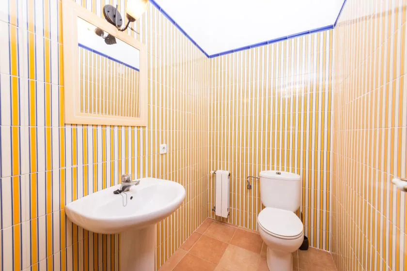 Un baño con azulejos, lavabo e inodoro.