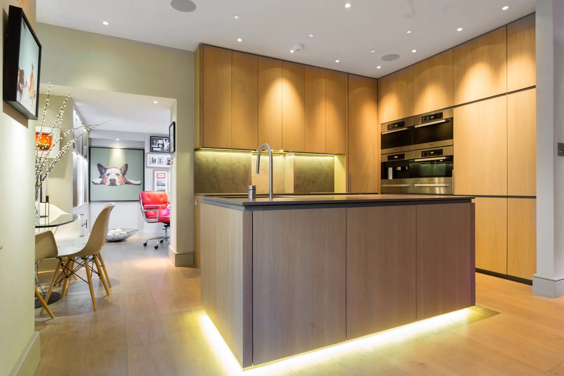 A modern kitchen with wood cabinetry and a large central island.