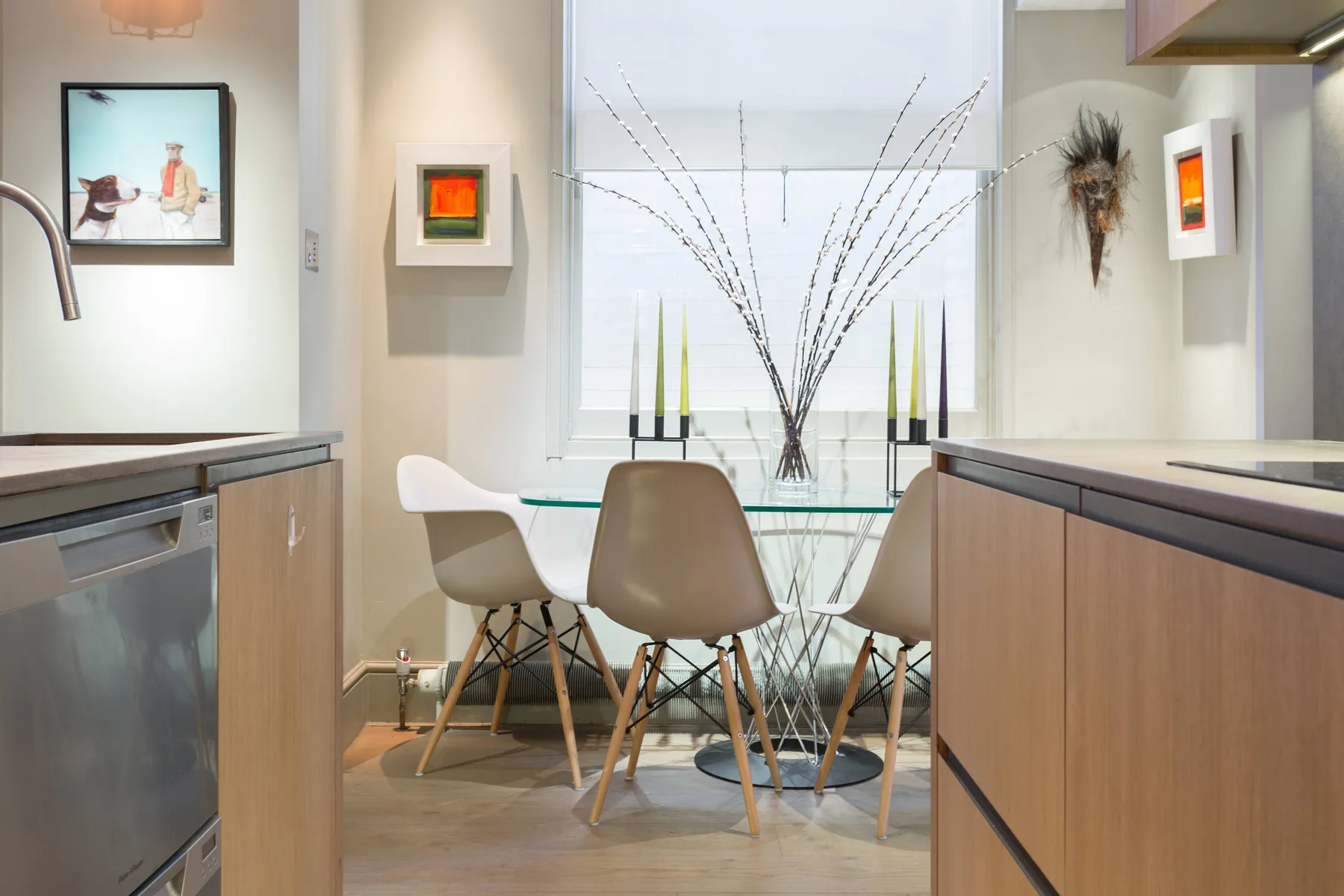 A dining area with a glass table and seating beside a large window.
