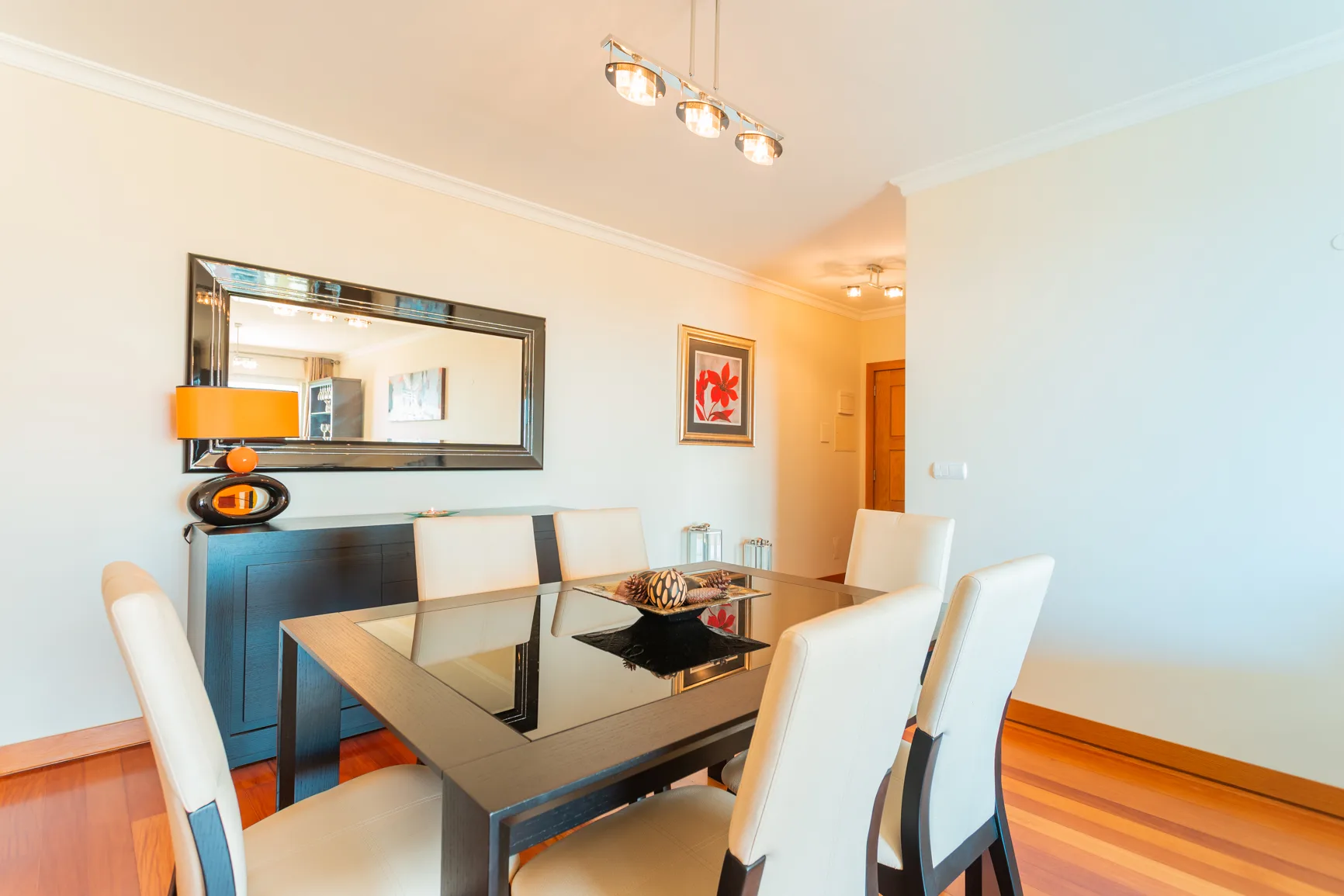 Dining area with a glass-topped table and upholstered seating.