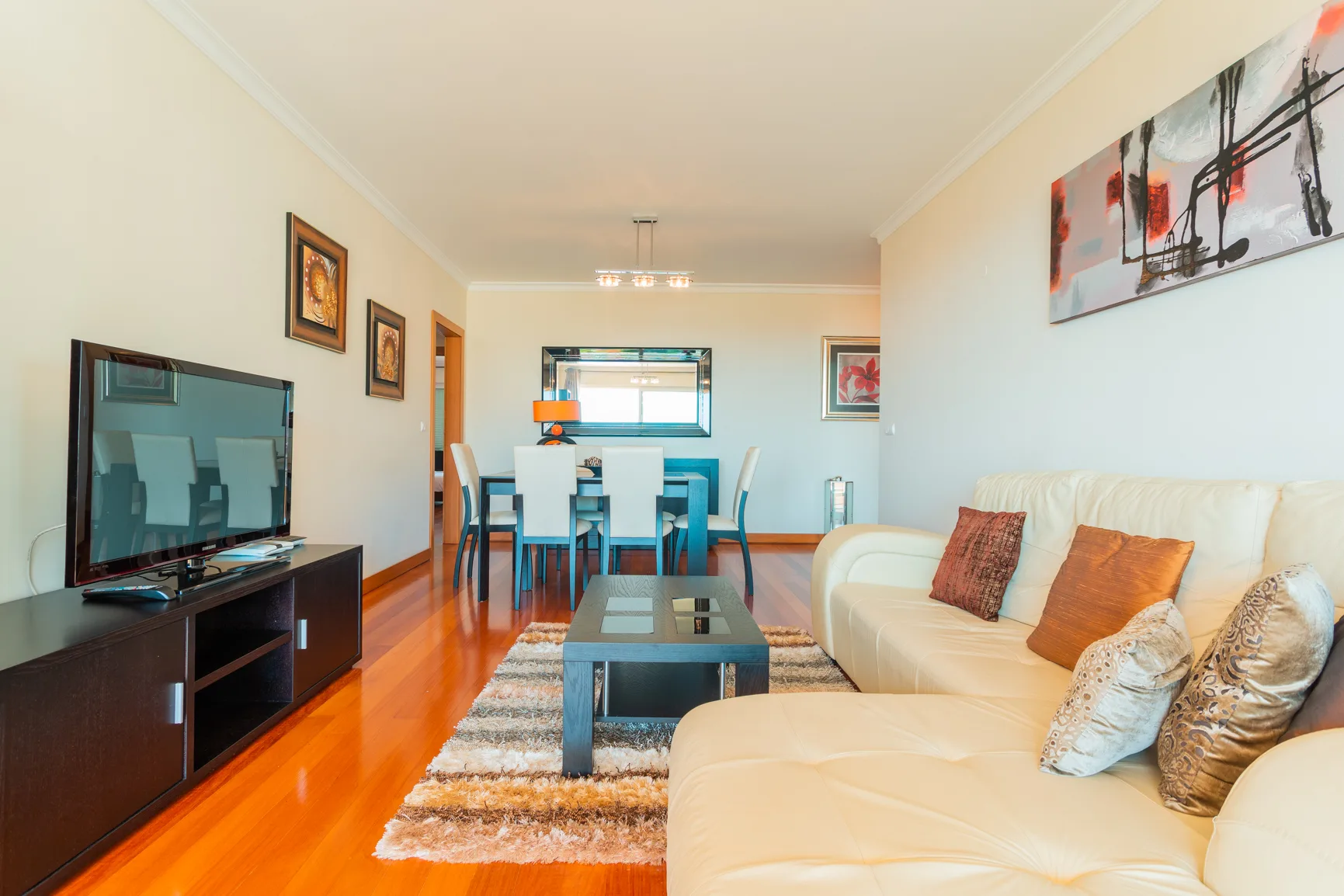 A living and dining area with seating, a coffee table, and a television.