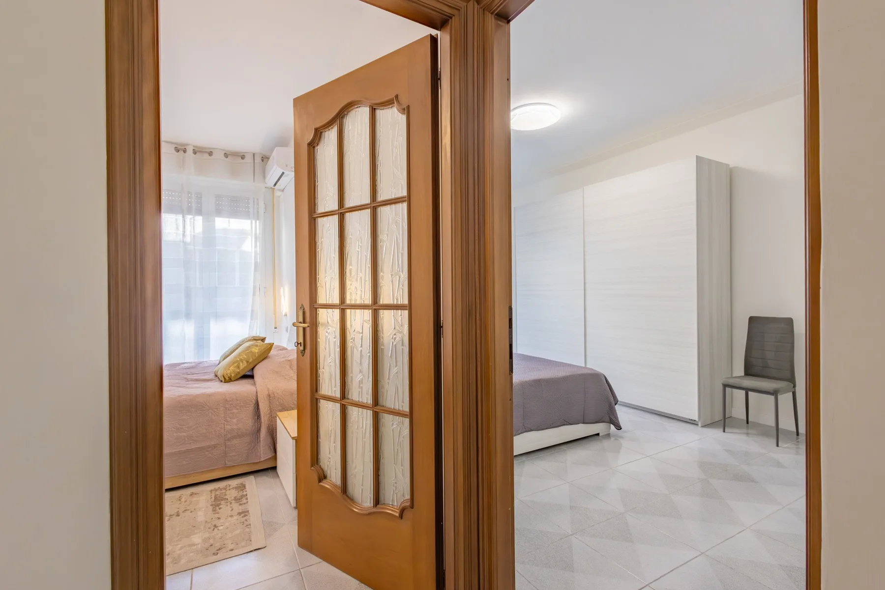 A bedroom with a bed, a wardrobe, and a chair.