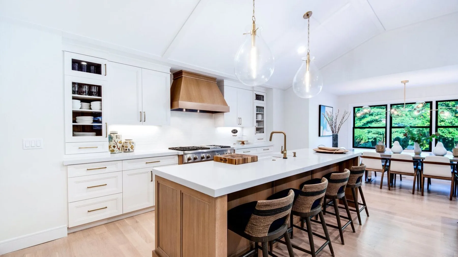 Una cocina luminosa con una isla central y grandes ventanas con vistas a la vegetación.