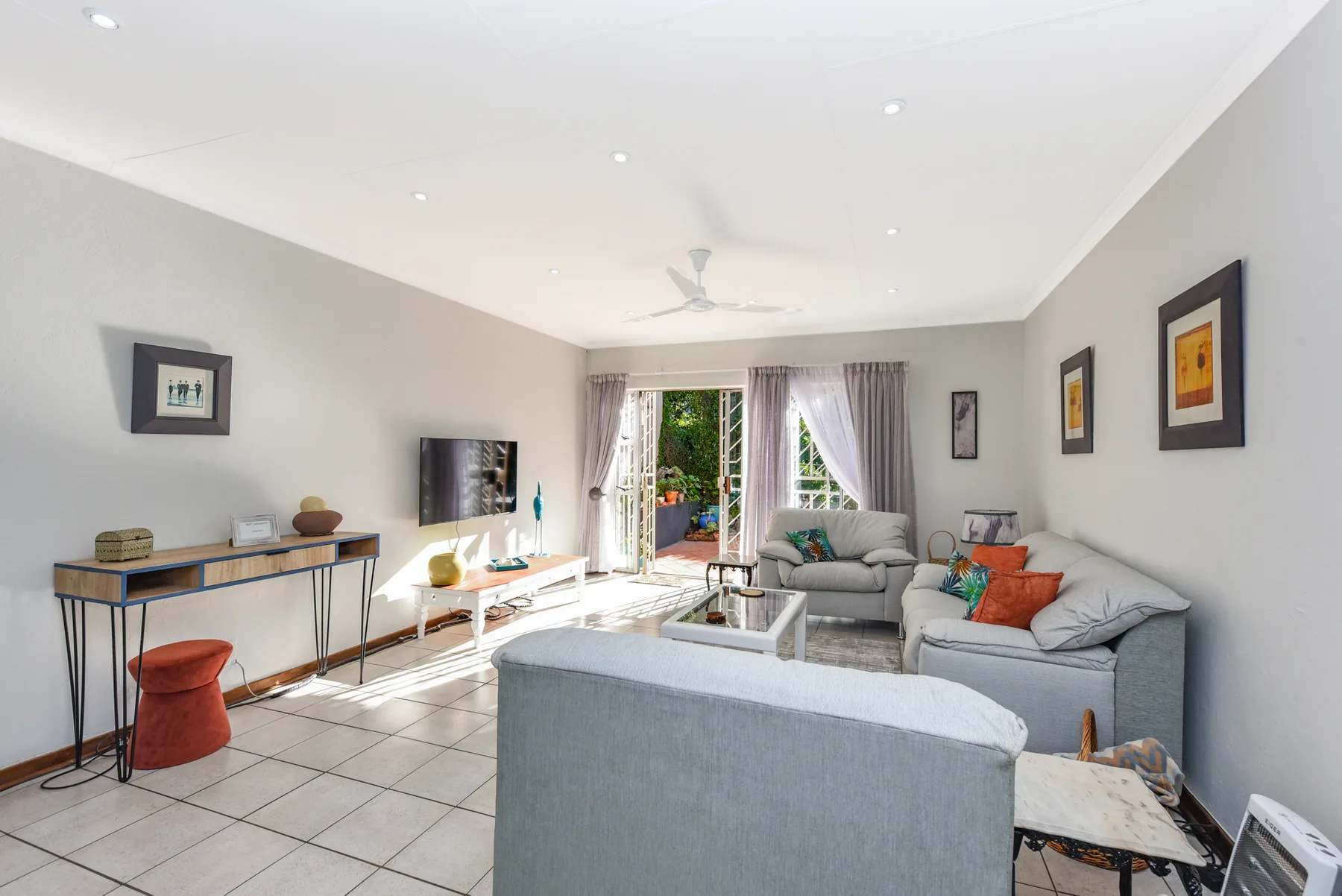 A bright living room with seating arranged around a glass coffee table.