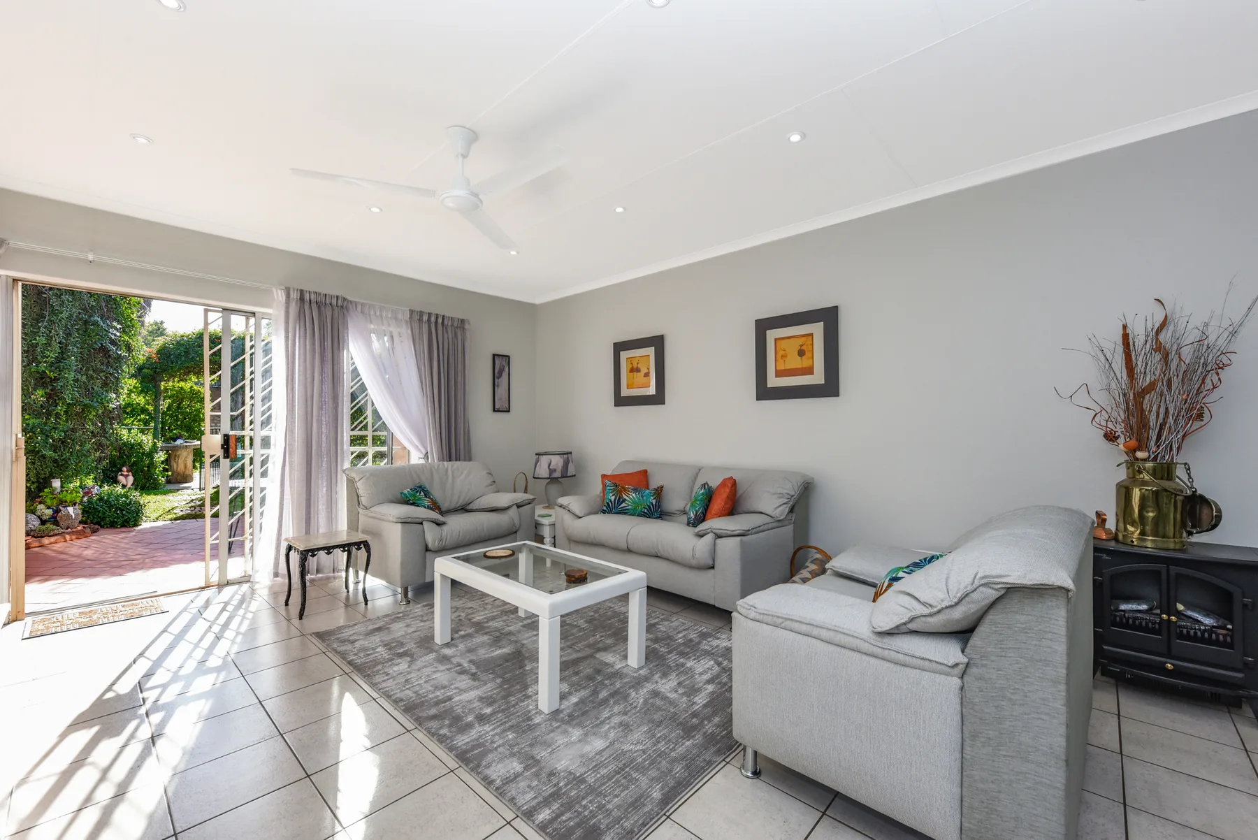 Living room with gray seating, a coffee table, and an open patio doorway.