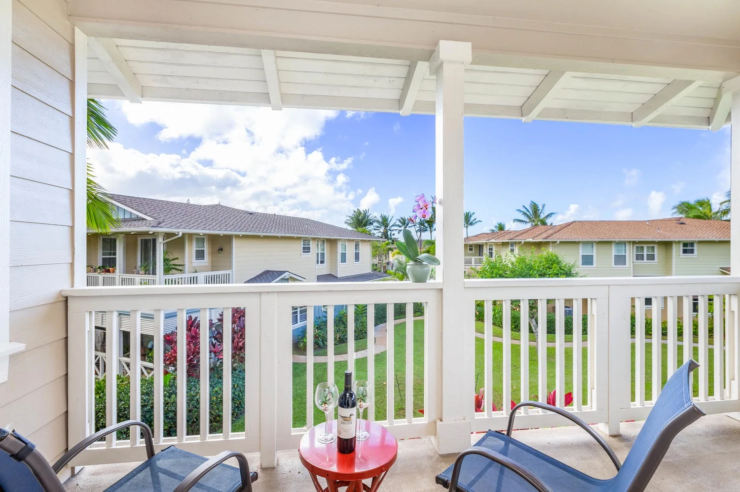 A covered outdoor patio overlooks neighboring homes and greenery.