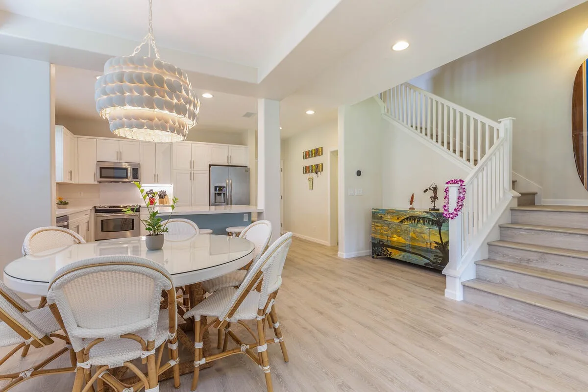 An open dining and kitchen area with a staircase beside the dining table.