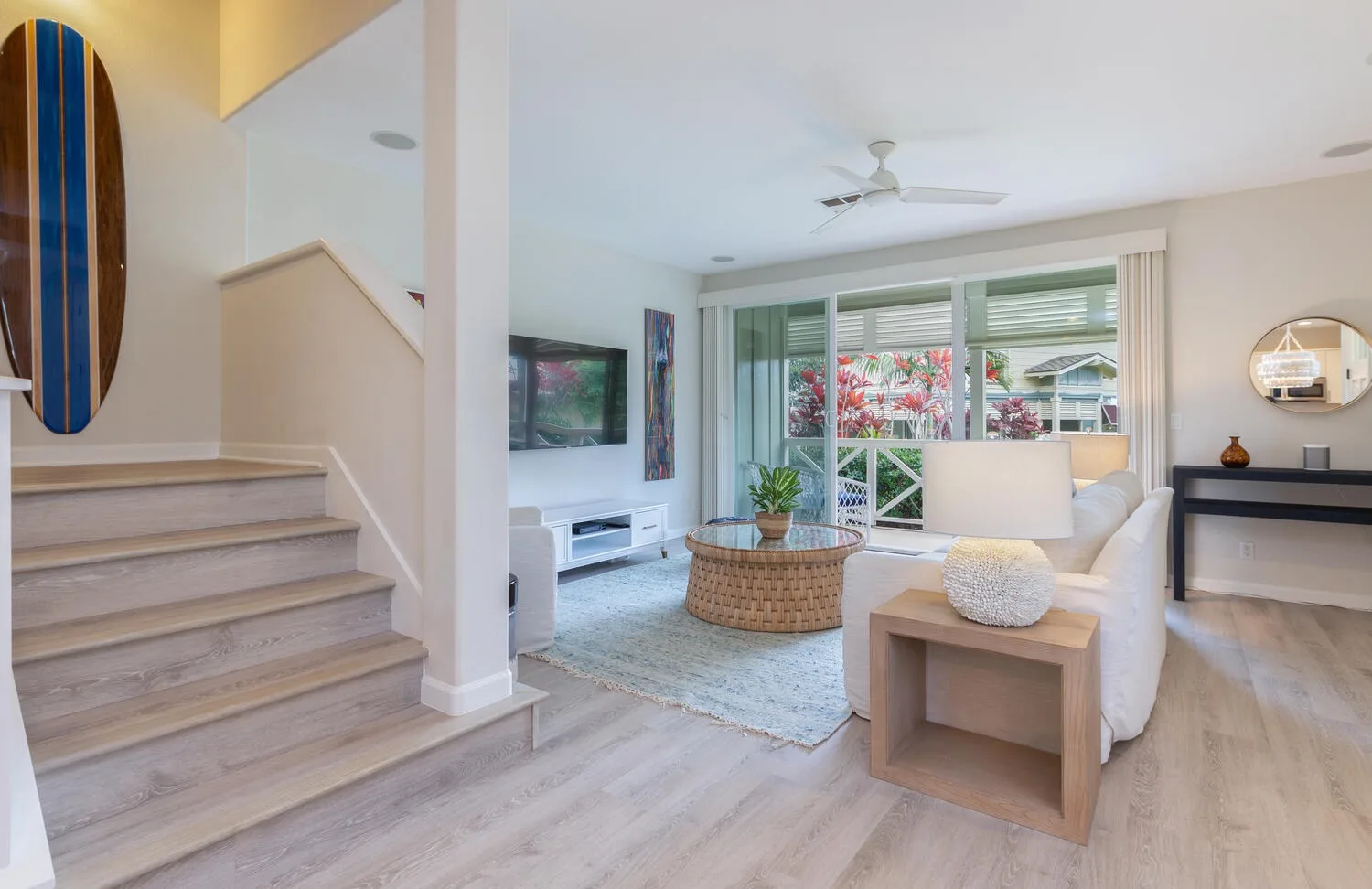 A bright living room with seating, a coffee table, and large windows.