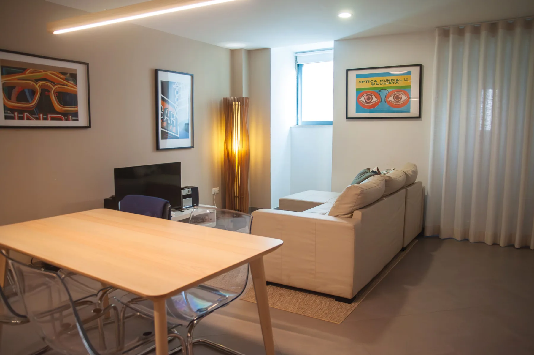 A living room with a dining table, seating, and framed artwork.