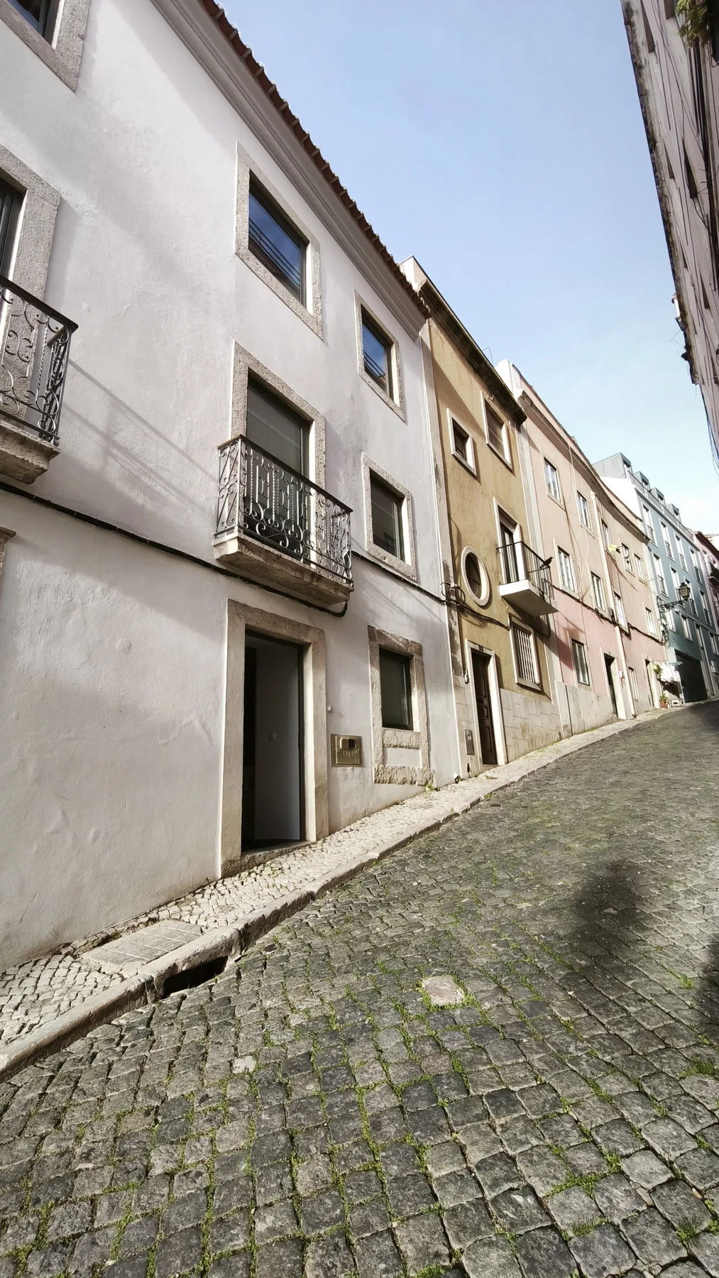 A narrow cobblestone street runs between rows of closely spaced buildings.