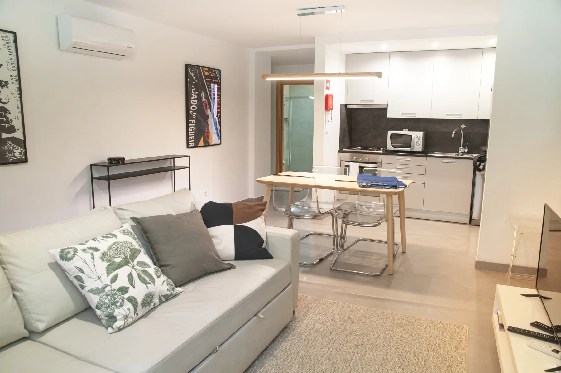 An open-plan living area with seating, a dining table, and a kitchen.