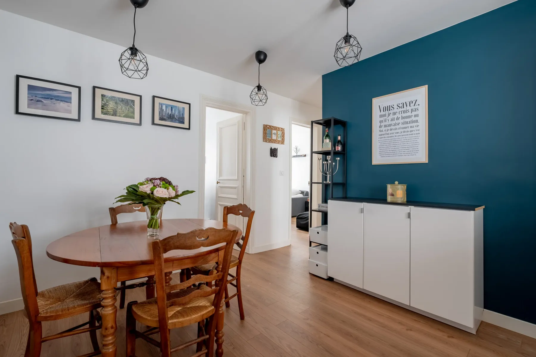 Comedor con una mesa de madera junto a una pared azul.