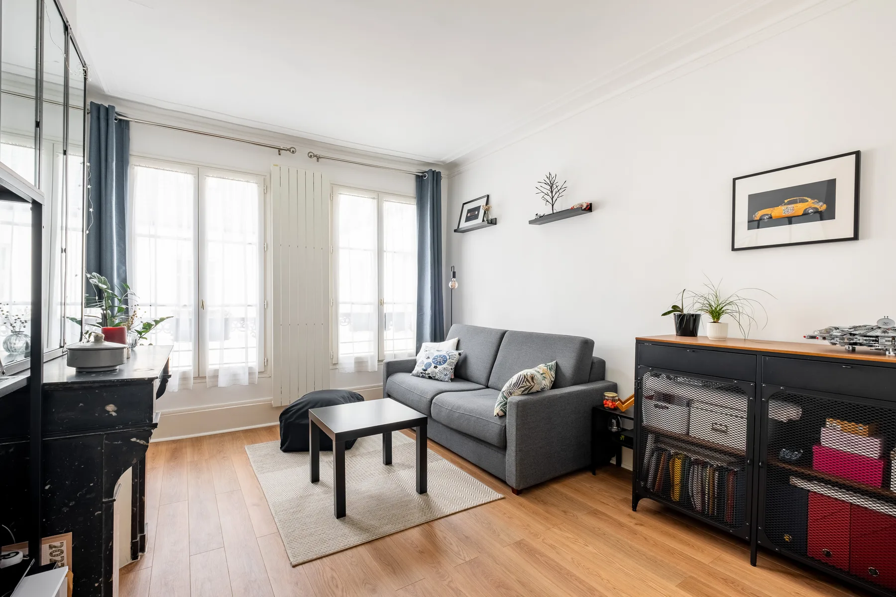 Living room with gray seating, a coffee table, and tall windows.