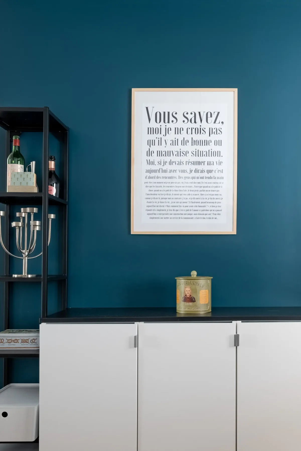 Una habitación con paredes azules, armarios blancos y una lámina enmarcada.