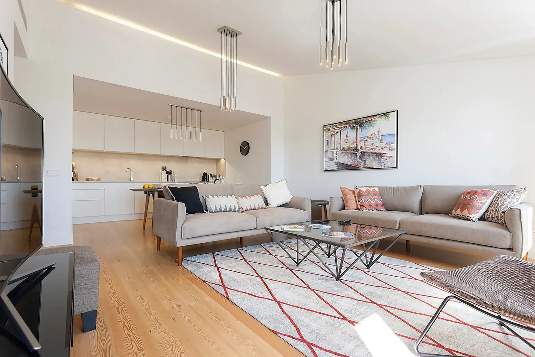 Una sala luminosa con una zona de asientos y una cocina abierta.