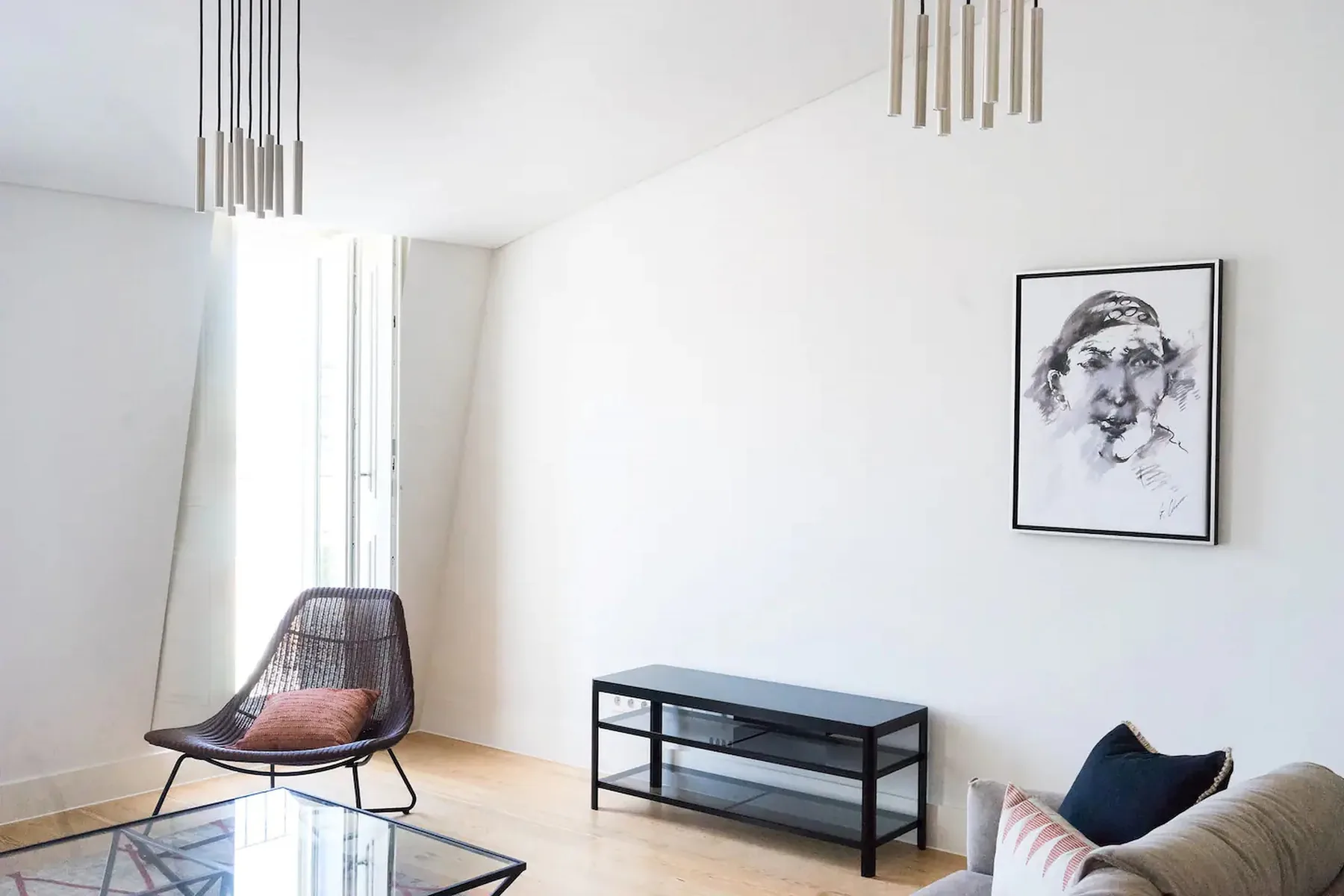Una sala luminosa con un asiento, una mesa baja y una obra enmarcada.