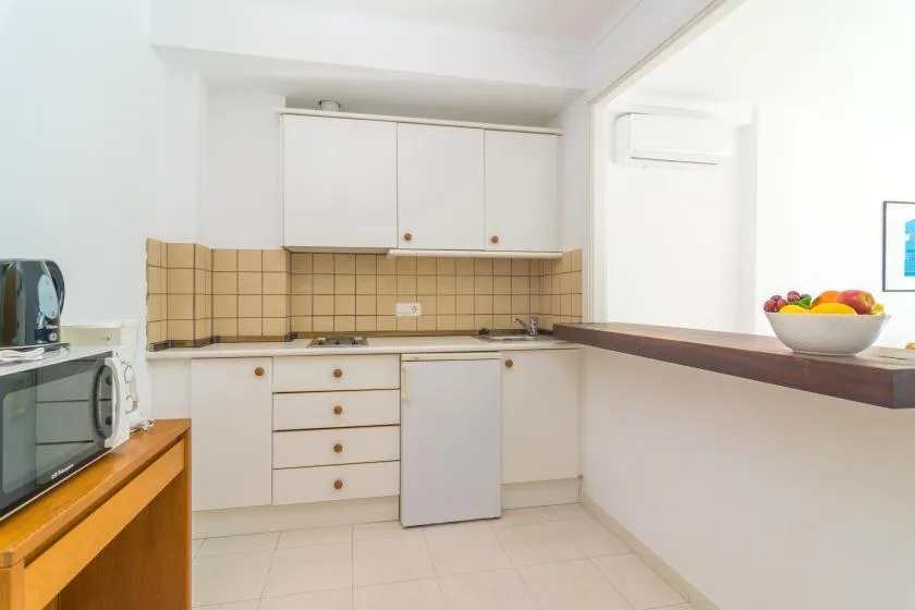 A bright kitchen with white cabinets, a tiled backsplash, and a countertop.